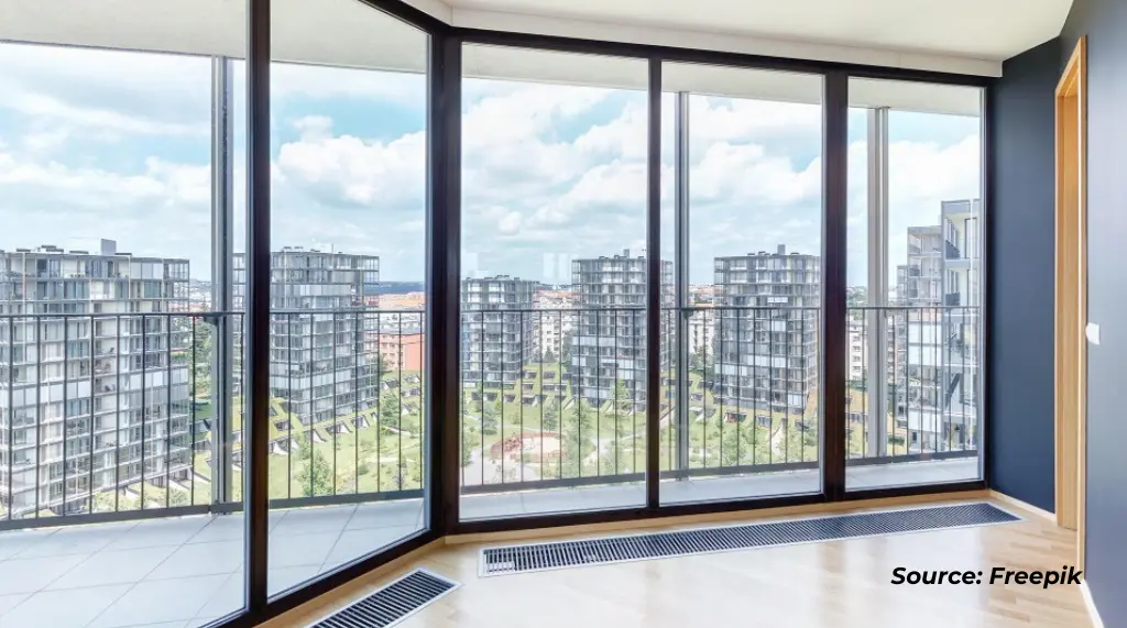 Pintu kaca aluminium di area balkon perkantoran dengan kusen warna hitam.