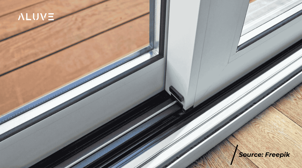 Pintu sliding aluminium warna putih dengan fokus pada rail sliding